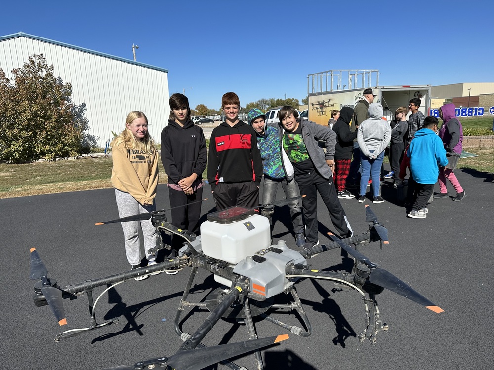 students with sprayer drone