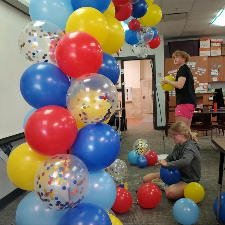 Students building a balloon arch.