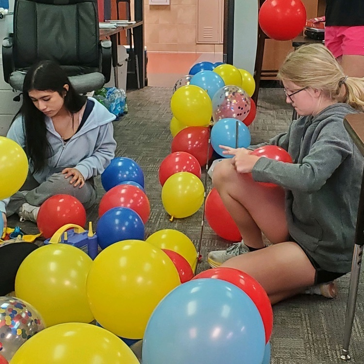 Students building a balloon arch. 